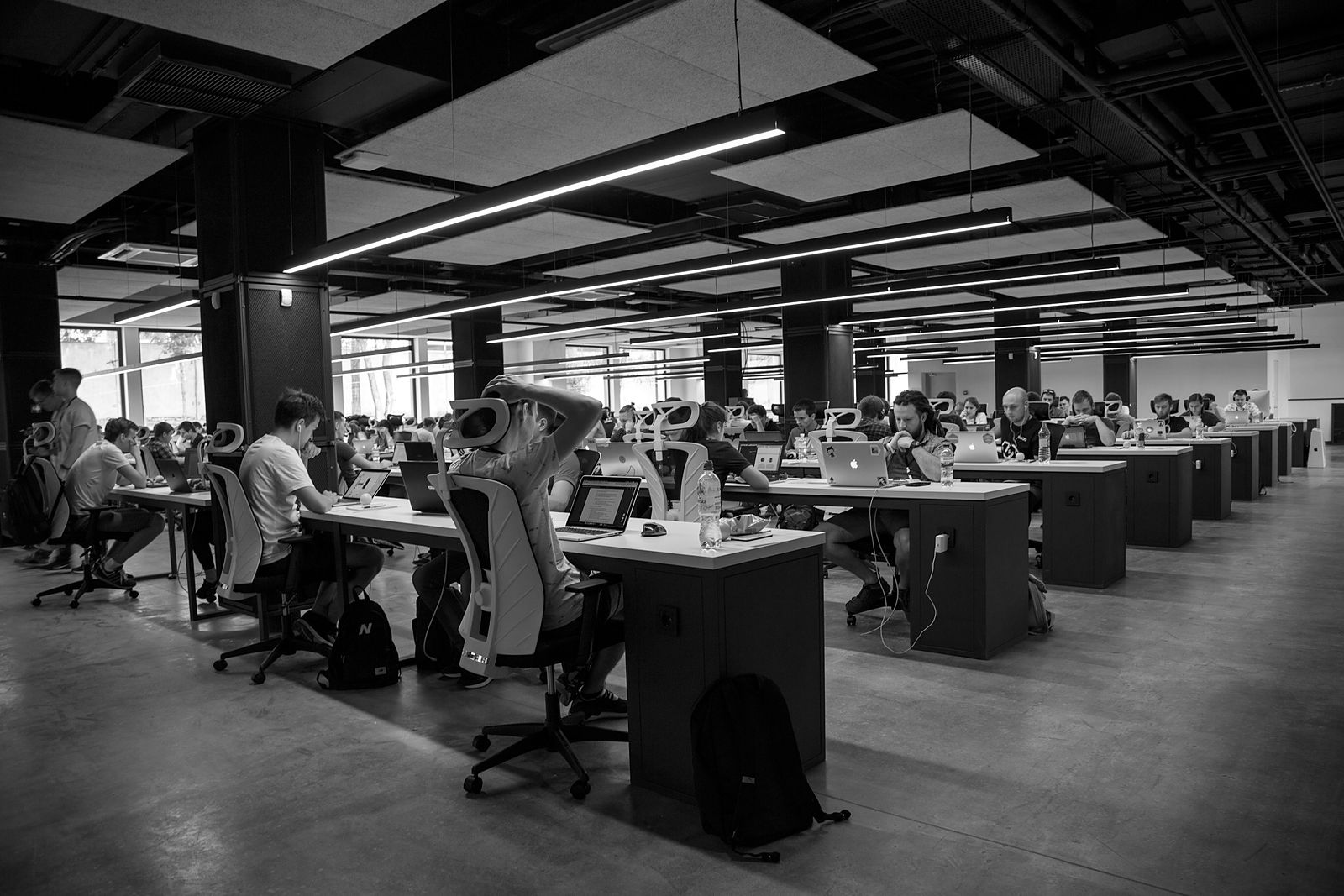 Oficina amplia con muchas personas trabajando en computadoras.